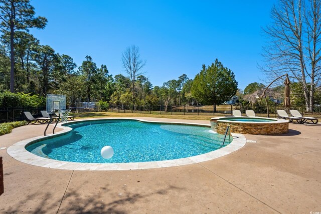 view of pool featuring a pool with connected hot tub, a patio area, and a fenced backyard