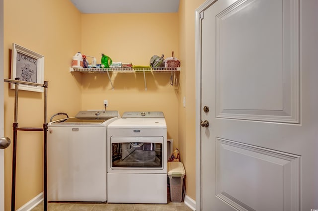 washroom featuring washer and dryer, baseboards, laundry area, and light tile patterned floors