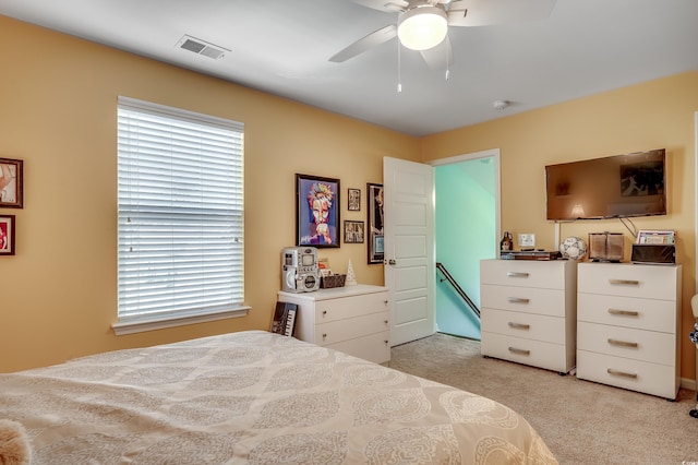 bedroom featuring visible vents, light colored carpet, and a ceiling fan