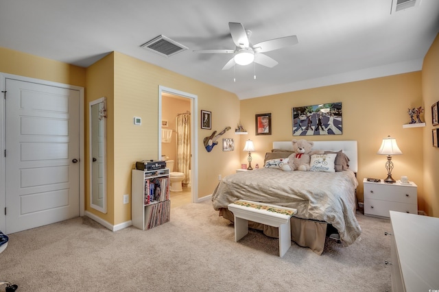 bedroom with baseboards, visible vents, ensuite bathroom, and light carpet