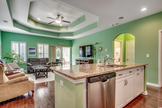 kitchen featuring a tray ceiling, stainless steel dishwasher, visible vents, and open floor plan