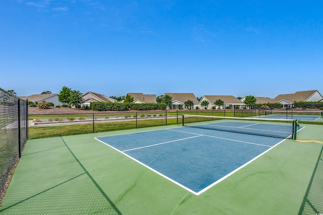 view of sport court with fence and a residential view