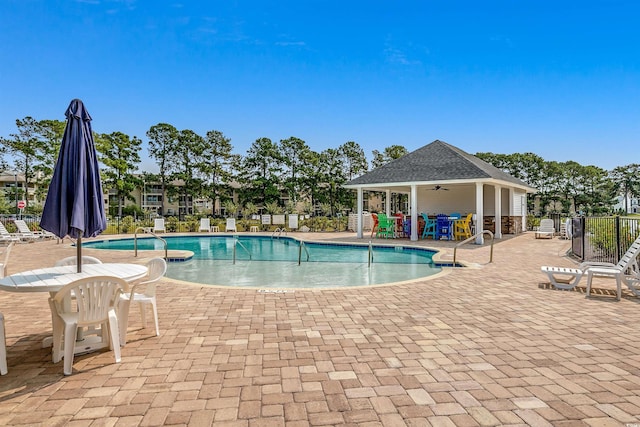 community pool with a ceiling fan, a patio, and fence