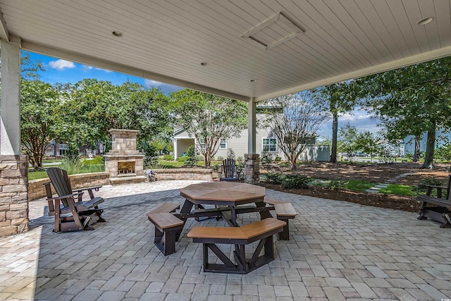 view of patio / terrace featuring outdoor dining space and an outdoor stone fireplace