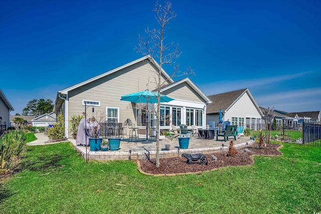 rear view of property featuring a yard, a patio, and fence