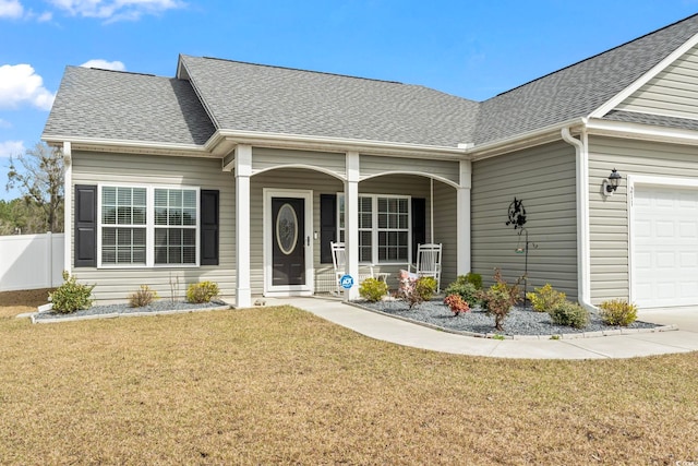 view of front of property featuring a front yard, fence, roof with shingles, a porch, and a garage