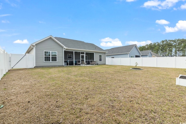 back of house with a yard, a fenced backyard, and a sunroom