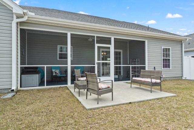 back of property featuring a patio area, fence, a lawn, and a sunroom