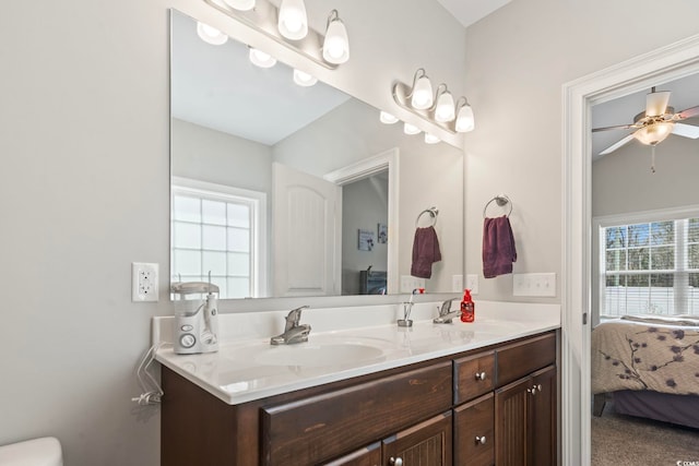 ensuite bathroom featuring double vanity, ensuite bath, ceiling fan, and a sink