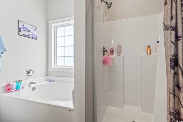 bathroom featuring a shower stall and a garden tub