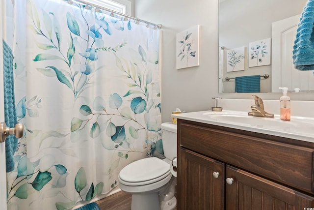 bathroom featuring toilet, vanity, a shower with curtain, and wood finished floors