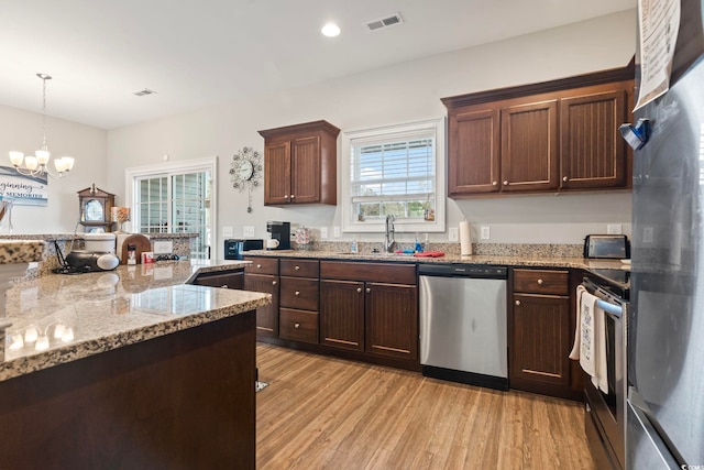 kitchen featuring light wood-style floors, visible vents, appliances with stainless steel finishes, and a sink