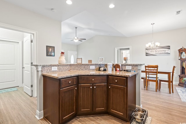 kitchen with visible vents, light wood-style flooring, ceiling fan with notable chandelier, dark brown cabinetry, and lofted ceiling