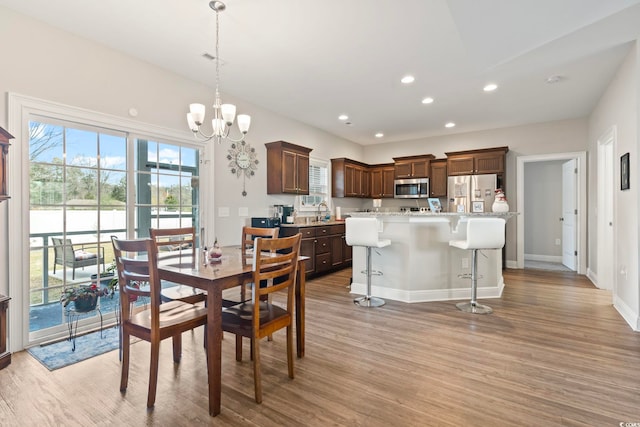 dining area featuring a chandelier, recessed lighting, light wood finished floors, and baseboards