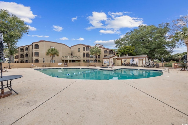 community pool featuring a patio and fence