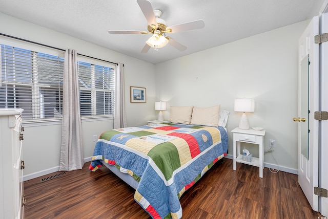 bedroom with visible vents, baseboards, wood finished floors, a textured ceiling, and a ceiling fan