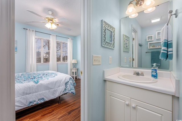 bathroom with ensuite bathroom, a ceiling fan, wood finished floors, and vanity