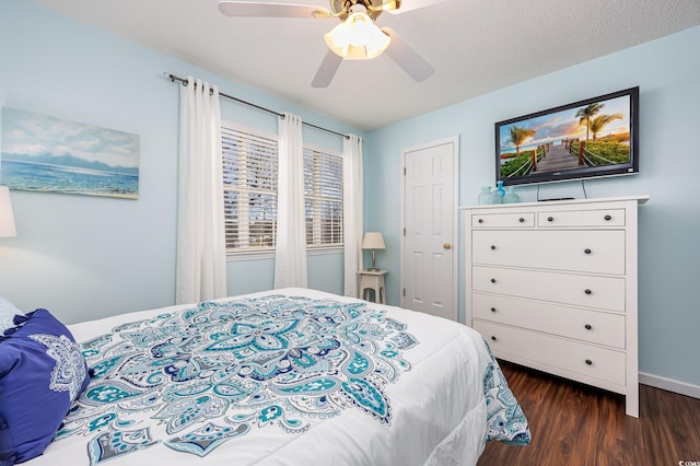 bedroom with baseboards, dark wood-type flooring, and ceiling fan