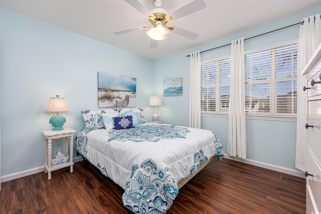 bedroom with visible vents, baseboards, wood finished floors, and a ceiling fan