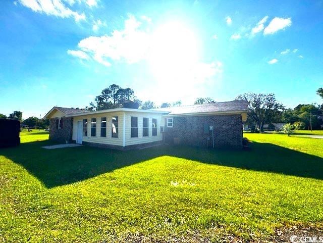 rear view of property with a yard