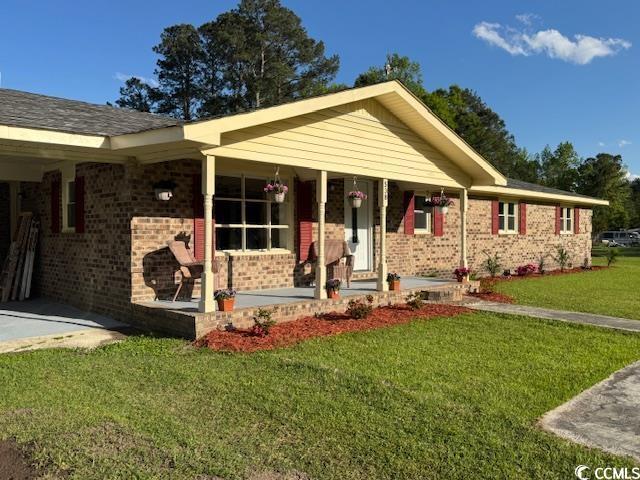 ranch-style home with brick siding and a front lawn