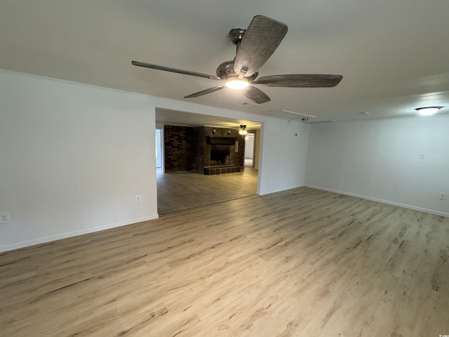 empty room featuring ceiling fan, attic access, wood finished floors, and baseboards