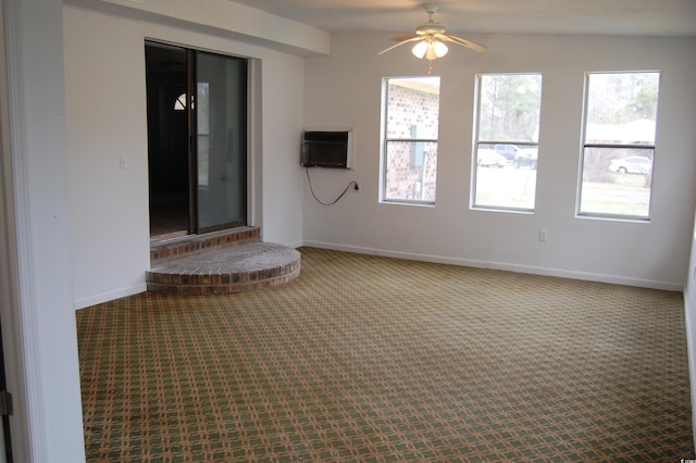 unfurnished room with carpet floors, baseboards, a ceiling fan, and a wall mounted AC
