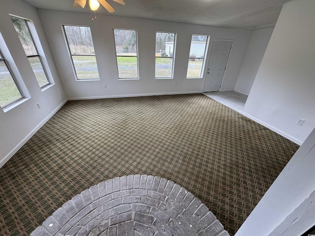 unfurnished room with a healthy amount of sunlight, baseboards, a ceiling fan, and carpet floors
