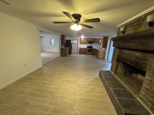 unfurnished living room with baseboards, a ceiling fan, and a brick fireplace