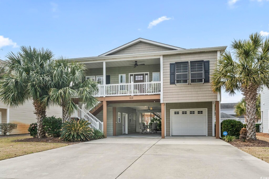 619 10th Ave S, North Myrtle Beach, SC 29582 - coastal inspired home with driveway, a ceiling fan, a porch, stairway, and a garage