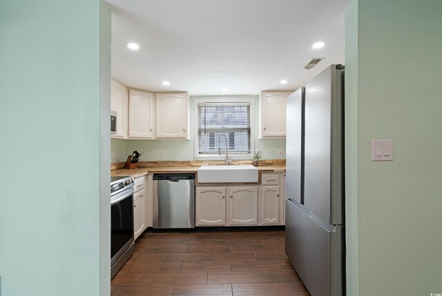508-B Rosemary Ln, North Myrtle Beach, SC 29582 - kitchen with appliances with stainless steel finishes, a sink, dark wood-style floors, white cabinets, and recessed lighting