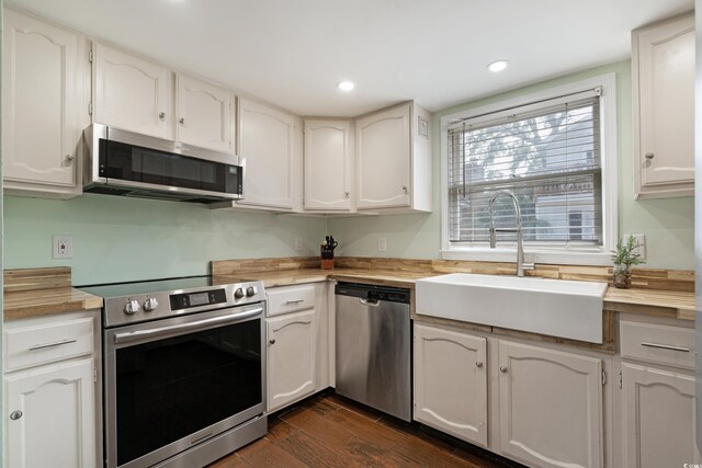 508-B Rosemary Ln, North Myrtle Beach, SC 29582 - kitchen with stainless steel appliances, butcher block countertops, a sink, dark wood-style flooring, and white cabinetry