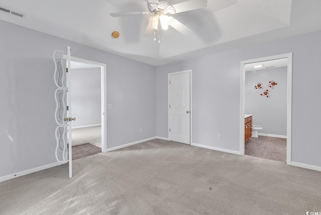 unfurnished bedroom with visible vents, baseboards, ceiling fan, carpet floors, and ensuite bath
