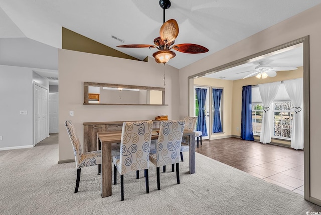 carpeted dining area featuring a ceiling fan, visible vents, lofted ceiling, tile patterned floors, and baseboards
