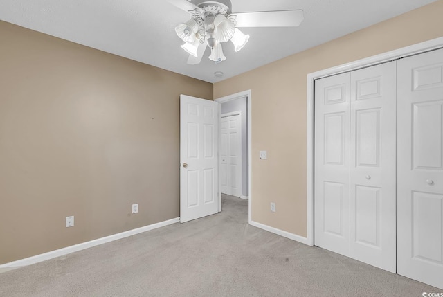 unfurnished bedroom featuring a closet, baseboards, a ceiling fan, and light colored carpet