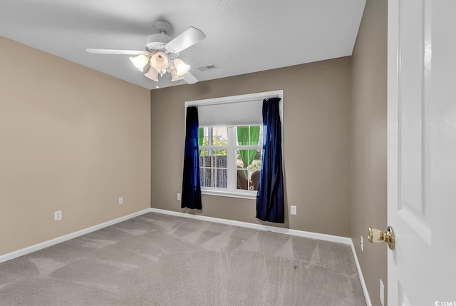 empty room featuring ceiling fan, visible vents, baseboards, and carpet floors