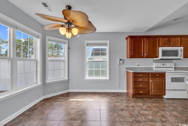 kitchen with visible vents, baseboards, light countertops, ceiling fan, and white appliances