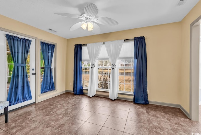 unfurnished room featuring ceiling fan, baseboards, tile patterned flooring, and visible vents