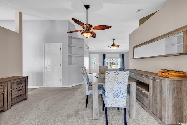 carpeted dining area featuring visible vents, baseboards, vaulted ceiling, and a ceiling fan