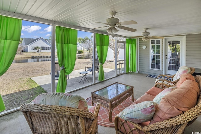 sunroom featuring a water view, a wealth of natural light, and a ceiling fan