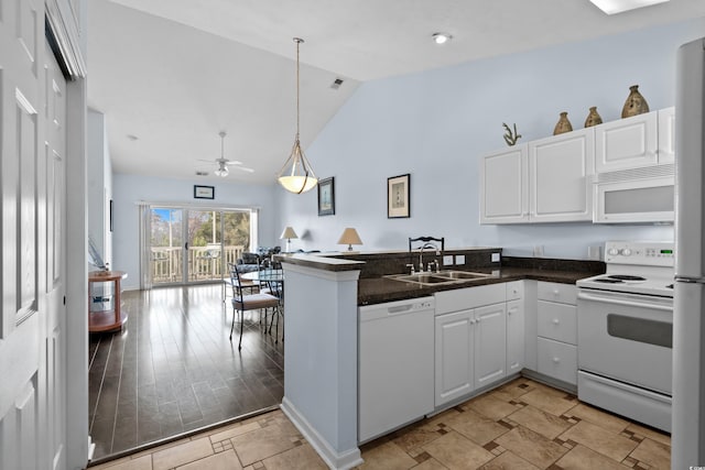 kitchen featuring a ceiling fan, a sink, white cabinetry, white appliances, and a peninsula