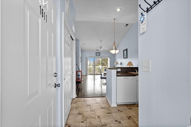 corridor with visible vents, lofted ceiling, and stone finish floor