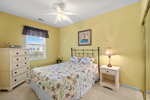 bedroom featuring light colored carpet, baseboards, visible vents, and ceiling fan