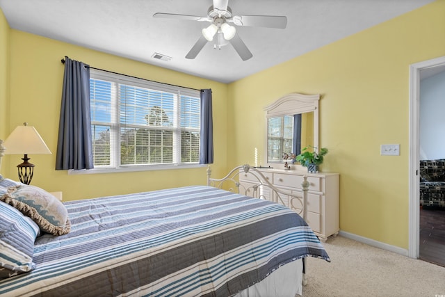 bedroom featuring visible vents, light carpet, baseboards, and ceiling fan