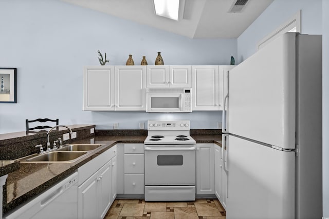 kitchen with visible vents, stone finish floor, a sink, white appliances, and white cabinets