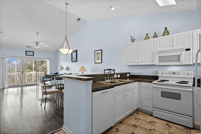 kitchen featuring white appliances, white cabinetry, a peninsula, and a sink