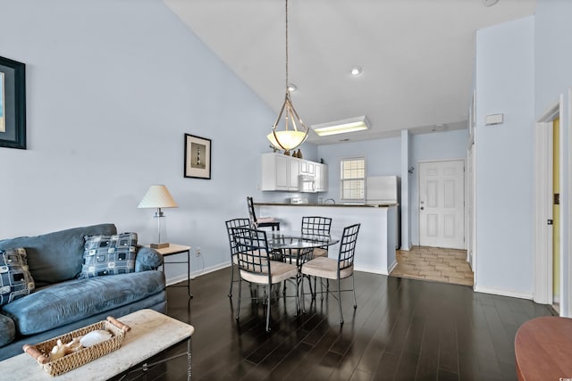 dining room featuring baseboards, dark wood-style floors, and vaulted ceiling