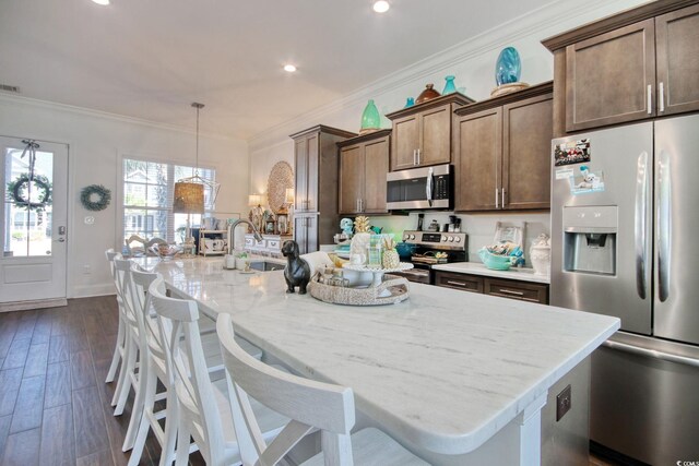 622 Lorenzo Dr Unit 622, North Myrtle Beach, SC 29582 - kitchen featuring appliances with stainless steel finishes, a center island with sink, light stone countertops, crown molding, and a breakfast bar area