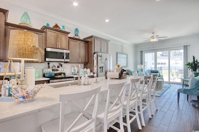 622 Lorenzo Dr Unit 622, North Myrtle Beach, SC 29582 - kitchen featuring stainless steel appliances, a breakfast bar, light countertops, crown molding, and recessed lighting