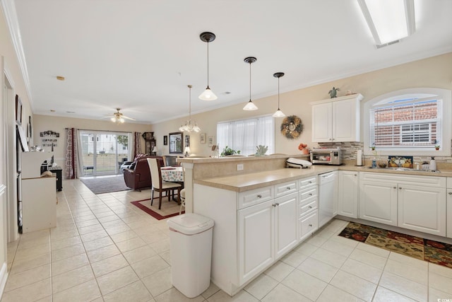 4142 Hibiscus Dr Unit 104, Little River, SC 29566 - kitchen featuring dishwasher, a peninsula, light tile patterned floors, decorative backsplash, and white cabinets